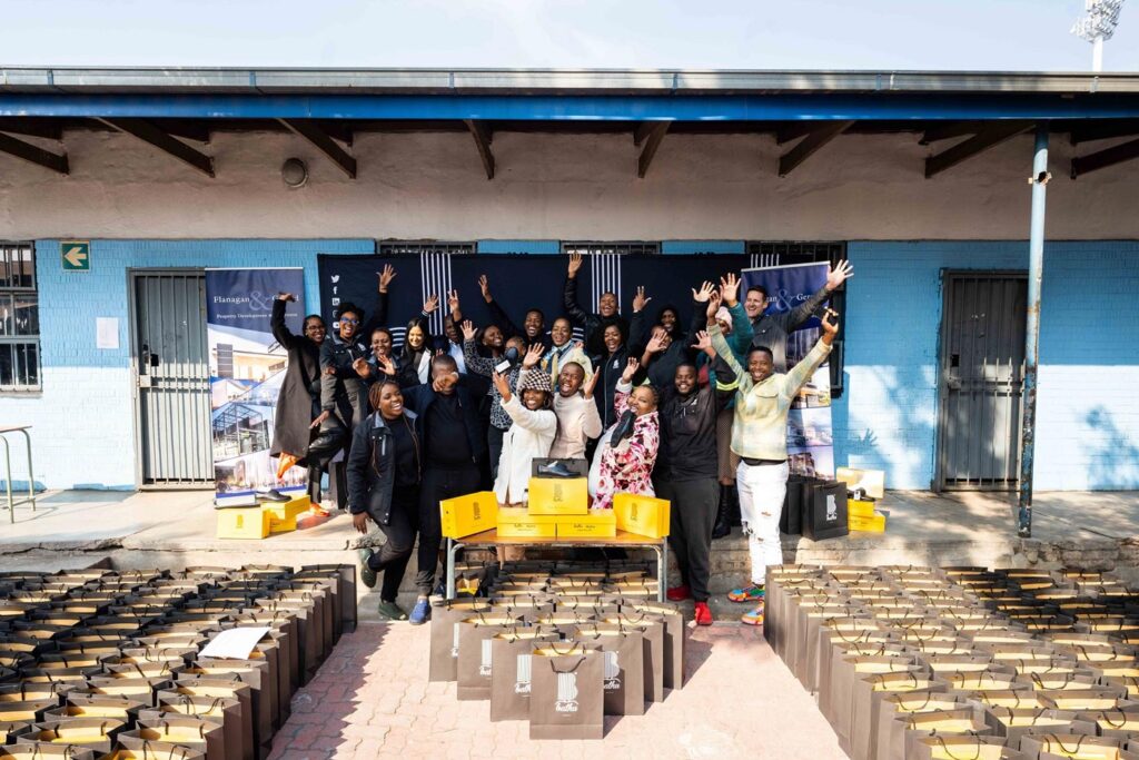 The Flanagan & Gerard team handing out Bathu shoes to the pupils at the Realogile Secondary School in Alexandra